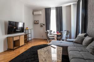 ein Wohnzimmer mit Sofa und Fernseher in der Unterkunft Luxury Vitosha Apartment in Sofia