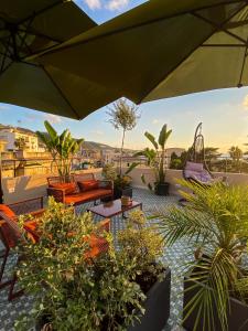 un patio avec de nombreuses plantes et un parasol dans l'établissement NoOne Tropea Guesthouse, à Tropea