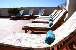 a row of wooden beds with blue blankets on them at De Los Arroyos Apart Hotel in San Nicolás de los Arroyos