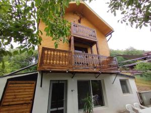 a house with a balcony on top of it at Rotwild House in Bicfălău