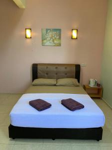 ein Bett in einem Zimmer mit zwei Handtüchern darauf in der Unterkunft TAMIM SUITE GROUP HOTEL Dungun in Dungun
