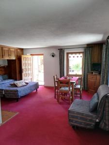 1 dormitorio con 1 cama, mesa y sillas en Residence Pavou, en Cogne