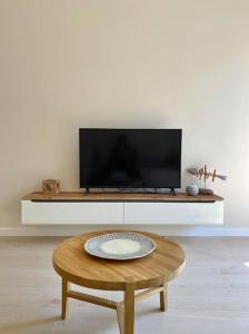 a living room with a coffee table and a flat screen tv at Harmony suite in the center of kalamata in Kalamata