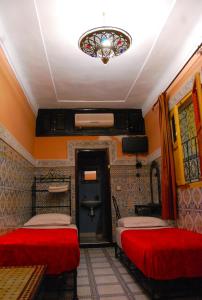 Zimmer mit 2 Betten und einem Kronleuchter in der Unterkunft Sindi Sud in Marrakesch