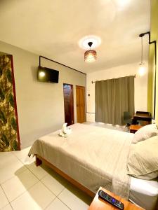 Un dormitorio con una cama con un teléfono. en Bijao Hostel en Tarapoto