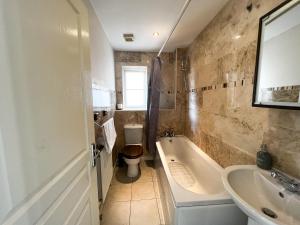 a bathroom with a tub and a toilet and a sink at 4 Bedroom house for Contractors,family,free parking,study,internet in ipswich in Ipswich
