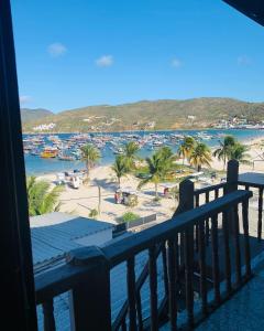 a balcony with a view of the beach and boats at Flat vista incrível in Arraial do Cabo