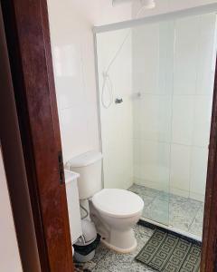 a bathroom with a toilet and a glass shower at Flat vista incrível in Arraial do Cabo