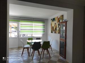 d'une salle à manger avec une table, des chaises et une fenêtre. dans l'établissement La Terraza de Castelao, à O Grove