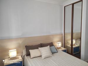 - une chambre avec un lit avec deux oreillers et deux lampes dans l'établissement La Terraza de Castelao, à O Grove