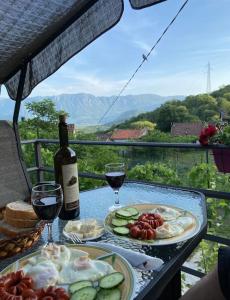 Una mesa con dos platos de comida y una botella de vino. en Old wine, en Virpazar