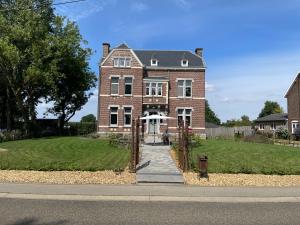 a large brick house with a walkway in front of it at B&B het Notarishuis in Voeren