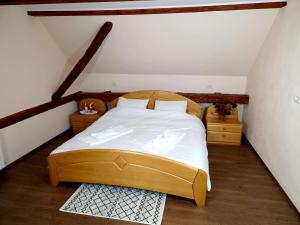 sypialnia z drewnianym łóżkiem na poddaszu w obiekcie Mehadica House w mieście Mehadica