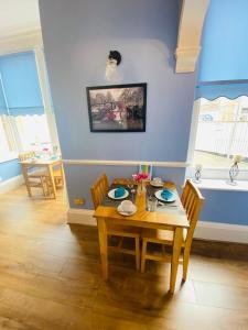 una sala da pranzo con tavolo e sedie in legno di All Seasons Bed & Breakfast - Adults Only a Weston-super-Mare