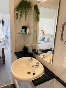 a bathroom with a sink and a mirror at All Seasons Bed & Breakfast - Adults Only in Weston-super-Mare