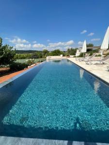 a swimming pool with blue water in a resort at Trullidamare a Ceglie Messapica, con piscina Infinity in Cisternino