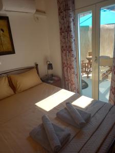 a bedroom with a bed with two towels on it at APANEMA HOUSE in Egina