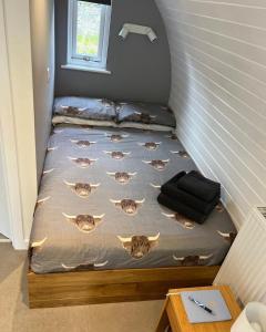 a small bed in a corner of a room at Loch Ness Pods, Pod 2 in Fort Augustus