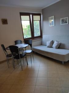 un soggiorno con un divano e un tavolo di Domek pod brzozami a Grzybowo