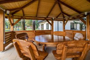 a wooden porch with a wooden table and chairs at Apartamenty Wakacyjna Wioska Ngô 20m od Suntago in Mszczonów