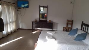 a bedroom with a bed and a dresser and a mirror at CABAÑAS RINCON DEL PLATA in Potrerillos