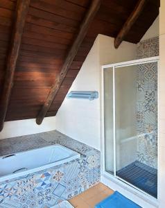 a bathroom with a tub and a glass shower at Sanctuary on Lois - under 1km from hospital - load shedding free in Pretoria