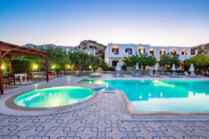 a pool at a resort with tables and chairs at Casa Garden in Karpathos