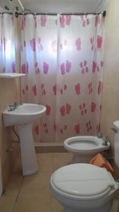 a bathroom with a toilet and a sink and a shower curtain at CABAÑAS RINCON DEL PLATA in Potrerillos