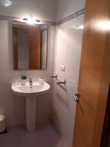 La salle de bains est pourvue d'un lavabo, d'un miroir et d'une douche. dans l'établissement Apartamento Reguiño al mar, à A Guarda