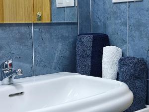 a bathroom with a white sink and a blue wall at Apartamento MAR y MONTAÑA ASTURIAS in Posada de Llanes