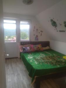 una camera con letto verde e finestra di Bor, Savaca - Porodicna Vikendica za Izdavanje a Bor