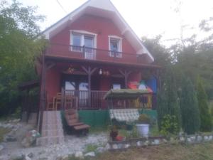 una casa rossa con portico e balcone di Bor, Savaca - Porodicna Vikendica za Izdavanje a Bor
