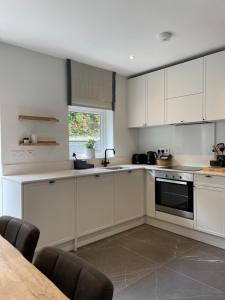 a kitchen with white cabinets and a table at The Village House in Malahide