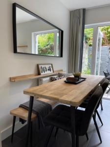 a dining room with a wooden table and a mirror at The Village House in Malahide