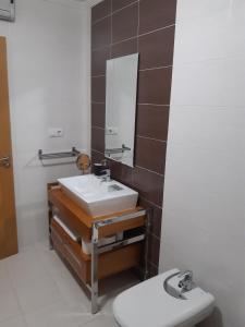 La salle de bains est pourvue d'un lavabo, d'un miroir et de toilettes. dans l'établissement Apartamento Reguiño al mar, à A Guarda