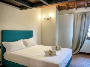 a bedroom with a bed with a blue headboard and gold shoes on it at Villaluce Wine Agriturismo in Castiglione del Lago