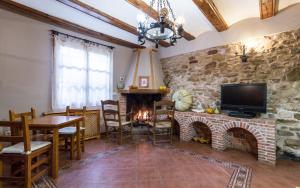 ein Wohnzimmer mit einer Steinmauer und einem Kamin in der Unterkunft Casa Rural La Yedra in Galve