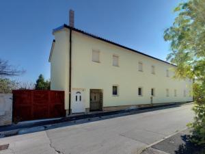 a white building with a red fence next to a street at Cinema House Single & Double Rooms & Studio Apartments in Pula
