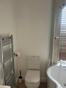 a bathroom with a toilet and a tub and a sink at Comfortably furnished 2 bedroom home in Bolton in Bolton