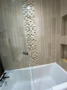 een badkamer met een douche en een wit bad bij Comfortably furnished 2 bedroom home in Bolton in Bolton