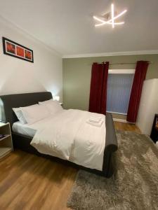 una camera da letto con un letto grande e un ventilatore a soffitto di Comfortably furnished 2 bedroom home in Bolton a Bolton