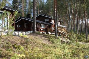 una baita nel bosco con alberi di Rock and Lake a Harjunmaa