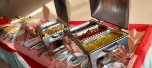 a table with three trays of food on it at Praia Boulevard Flat Porto Bahia in Porto Seguro