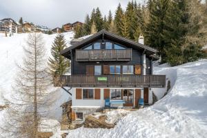 una casa in legno nella neve con gli alberi di Tschiffra OG a Bettmeralp