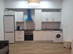 a kitchen with white cabinets and a washing machine at Premier Apartments in Valencia