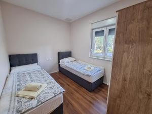 - une chambre avec 2 lits et une fenêtre dans l'établissement Medjugorje Apartments Centre, à Međugorje