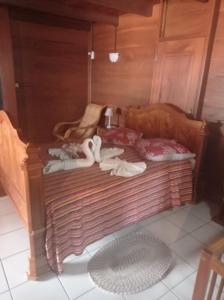 un lit en bois avec des cygnes assis au-dessus dans l'établissement Villavacances, à Bouillante