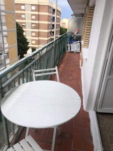 - Balcón con mesa blanca y 2 sillas en Sun & Sea 3 Bedroom Apartment de Grau en Gandía