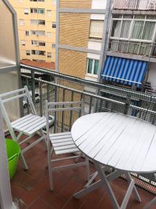 - Balcón con mesa blanca y 2 sillas en Sun & Sea 3 Bedroom Apartment de Grau, en Gandía