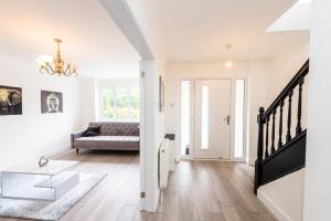 a white living room with a couch and a table at Fabulously presented 3 / 4 bedroom home in Woolton